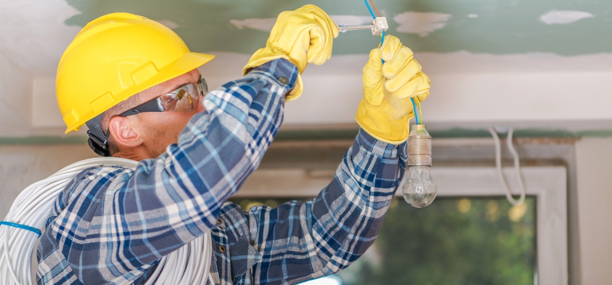 Técnico realizando instalación eléctrica en hogar con materiales seguros.