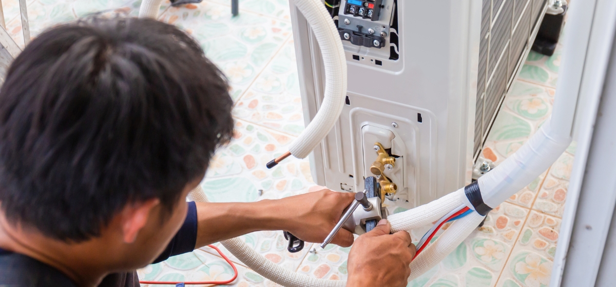 Técnico realizando mantención de aire acondicionado en oficina